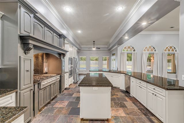 a kitchen with stainless steel appliances granite countertop a stove a sink and a microwave