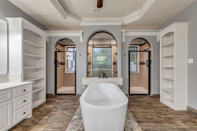 a living room with furniture a large window and wooden floor