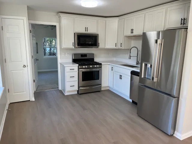 a kitchen with stainless steel appliances a refrigerator sink and microwave