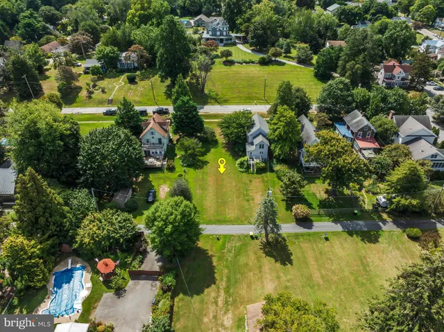 an aerial view of residential houses with outdoor space and trees all around