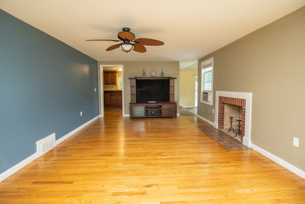 139 Fox Hill Road Springfield, MA 01118 - Photo 15 of 36 a view of a livingroom with a fireplace a ceiling fan and wooden floor