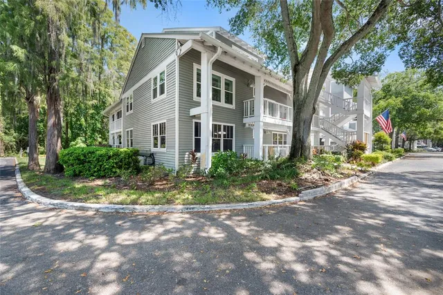 a front view of a house with a yard and potted plants