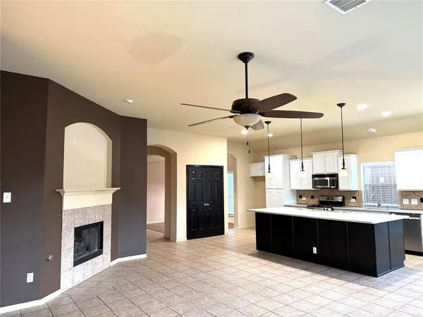 a living room with stainless steel appliances kitchen island granite countertop furniture and a fireplace