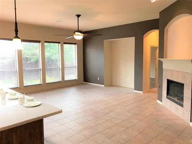 a view of an empty room with a fireplace and a window