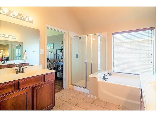 a bathroom with a tub a sink and a large mirror