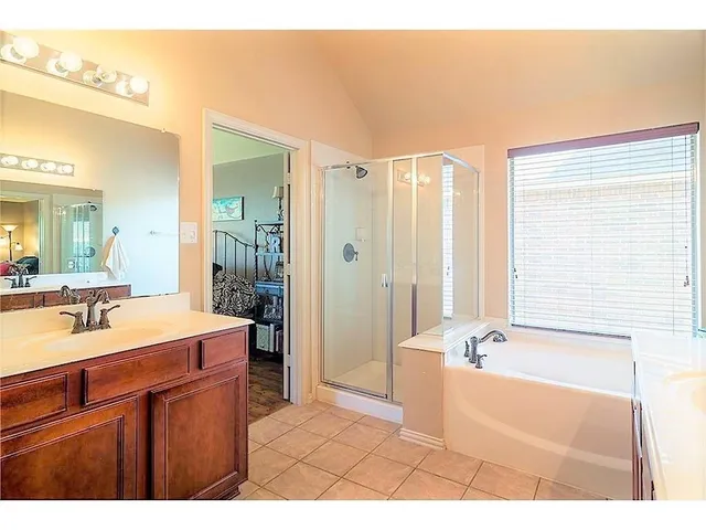 a bathroom with a tub a sink and a large mirror