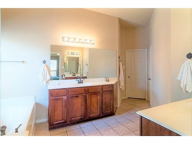 a spacious bathroom with a mirror and a sink