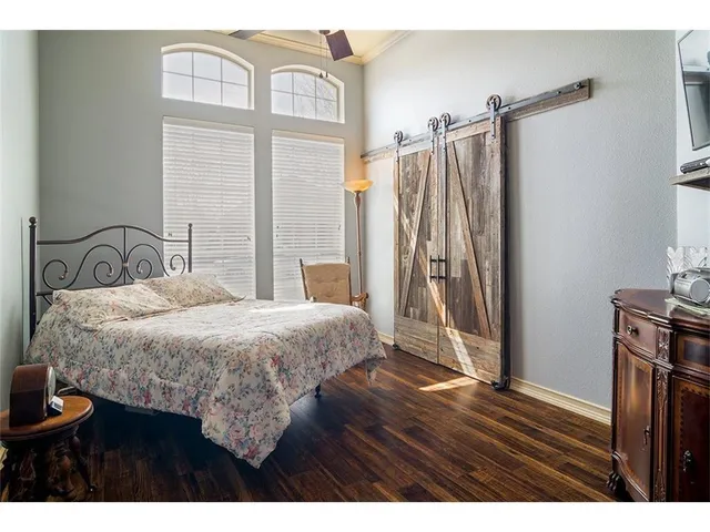 a bedroom with a bed and a flat tv screen on a dresser