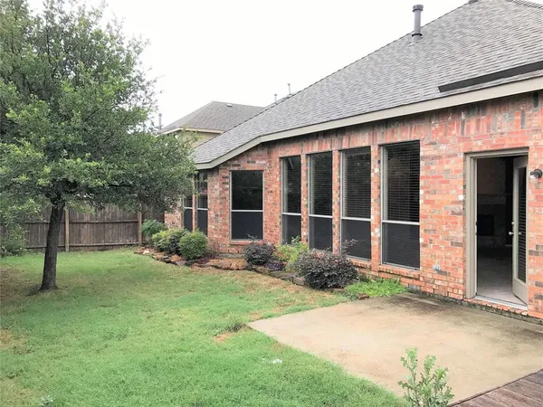 a view of a house with a yard and large tree