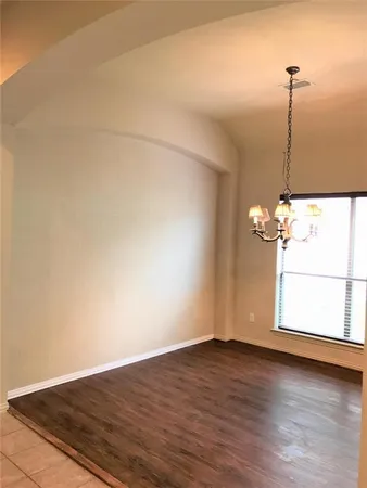 a view of a room with wooden floor fan and window