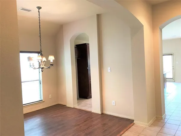 a view of a room with wooden floor chandelier and window