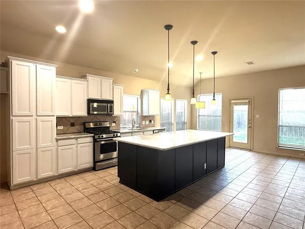 a kitchen with stainless steel appliances granite countertop a sink counter space and a view of living room