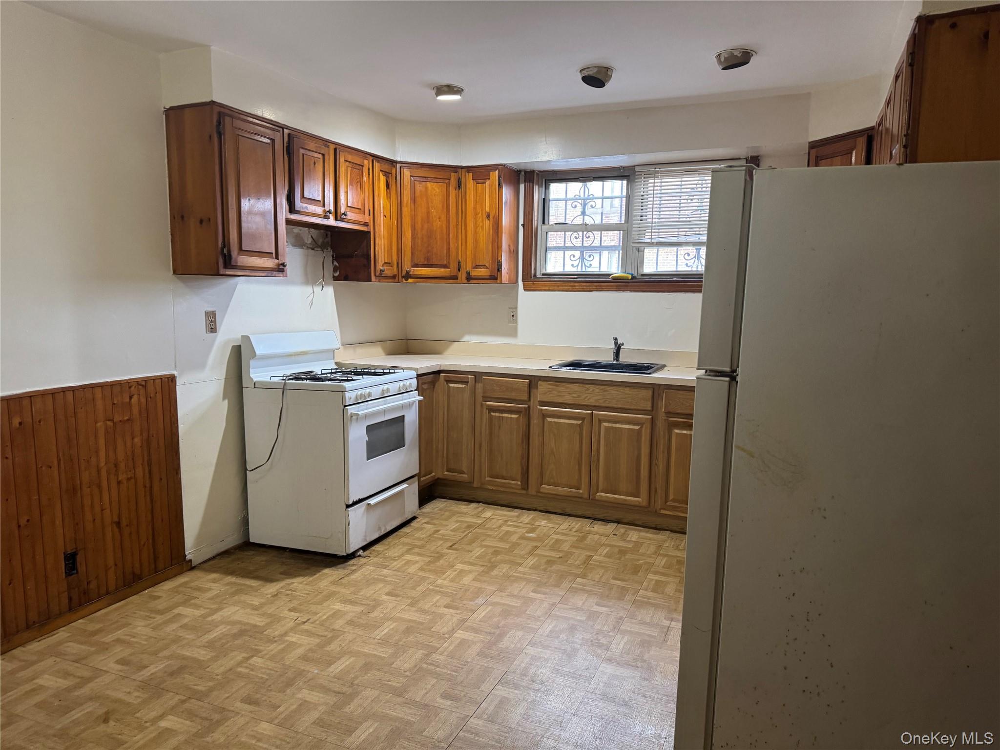 4557 White Plains Road Bronx, NY 10470 - Photo 3 of 5 a kitchen with a sink stove and cabinets