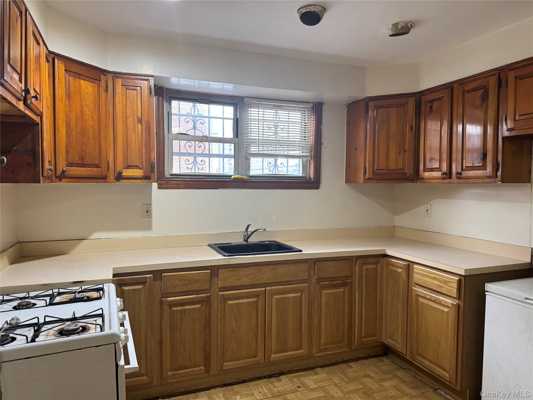4557 White Plains Road Bronx, NY 10470 - Photo 4 of 5 a kitchen with stainless steel appliances granite countertop a sink stove and cabinets