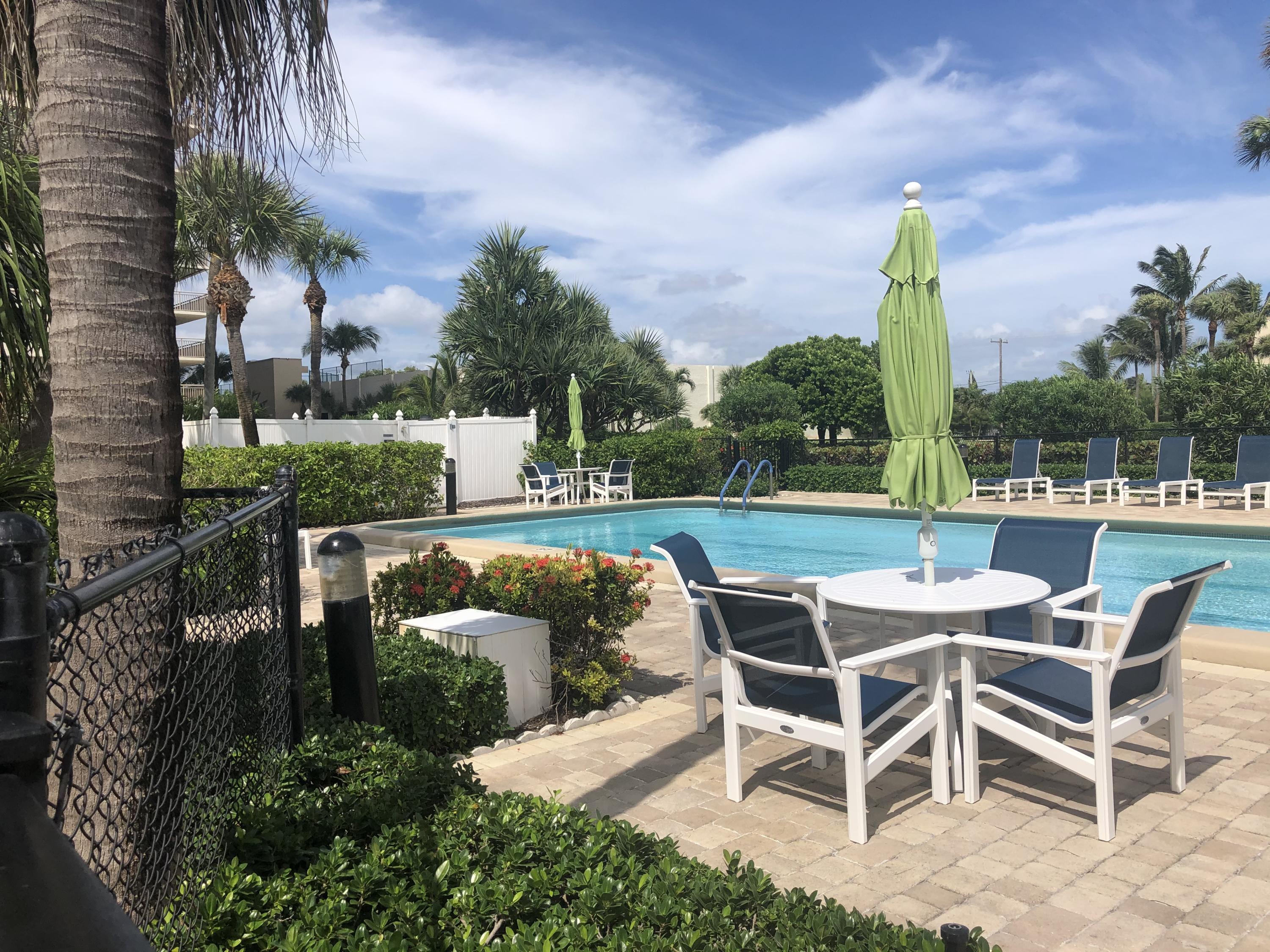 3400 North Ocean Drive, Unit 306 Riviera Beach, FL 33404 - Photo 30 of 52 a patio with table and chairs and potted plants
