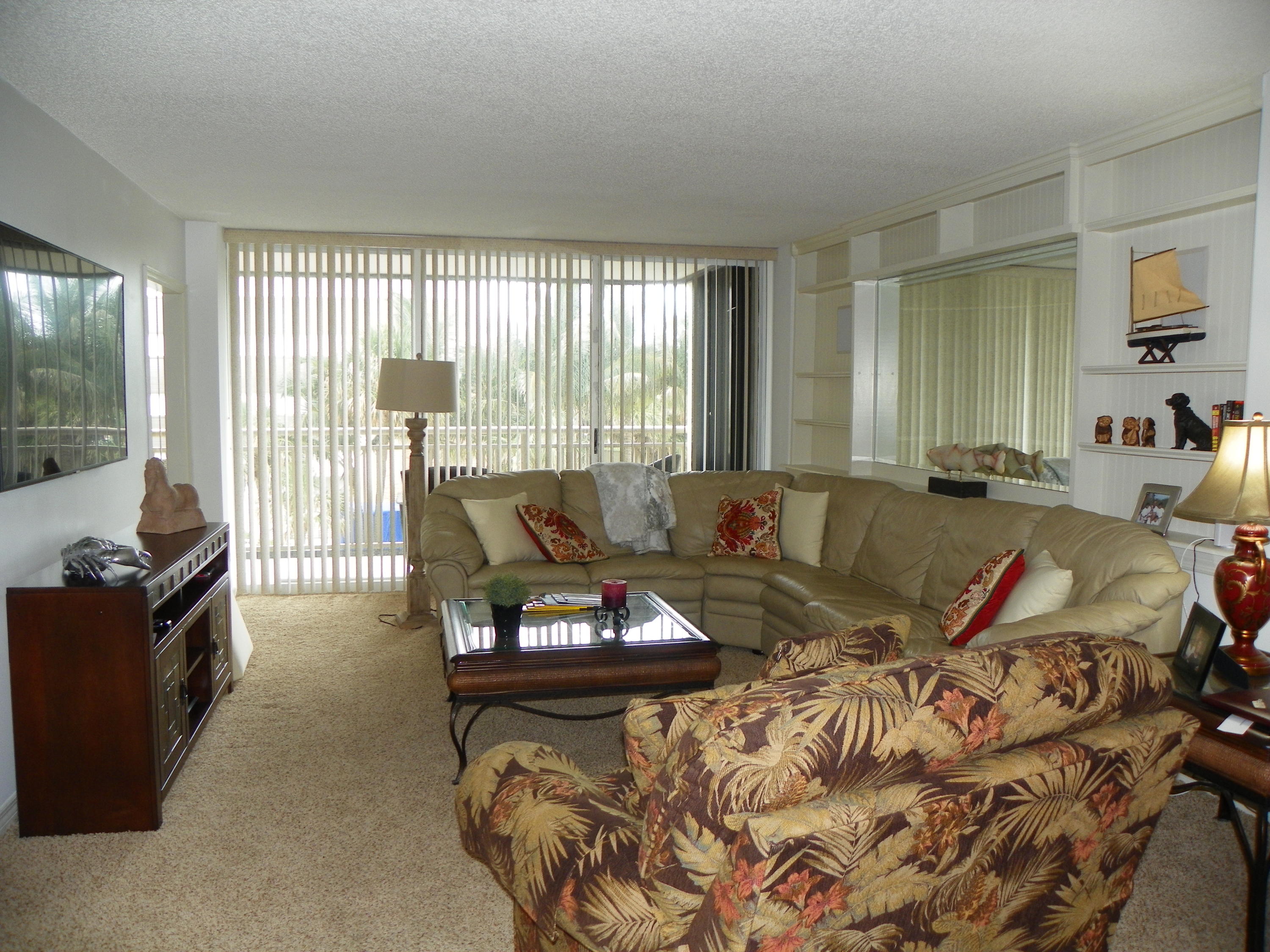 3400 North Ocean Drive, Unit 306 Riviera Beach, FL 33404 - Photo 6 of 52 a living room with furniture and a flat screen tv