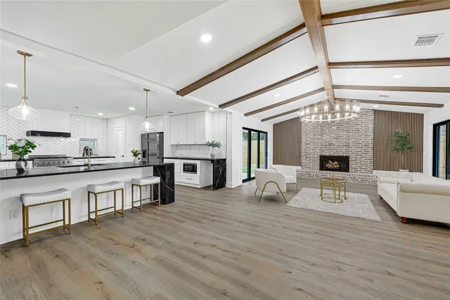 a large white kitchen with stainless steel appliances granite countertop a stove and cabinets