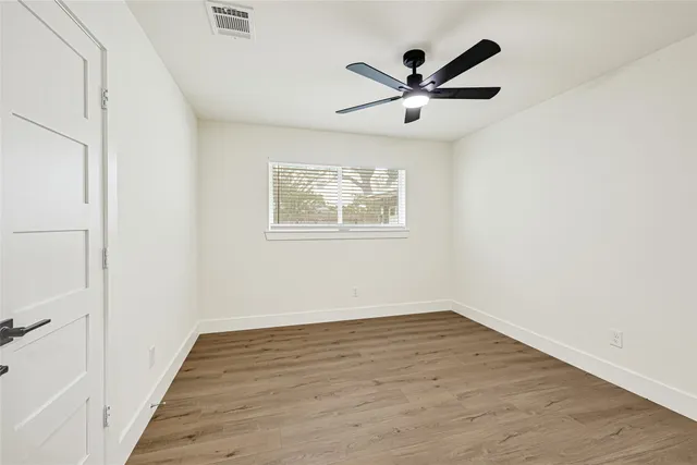 a view of a big room with wooden floor and windows