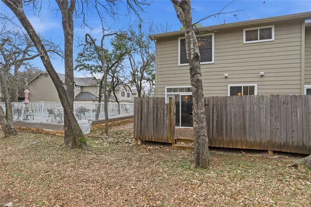 a view of a house with backyard and wooden fence