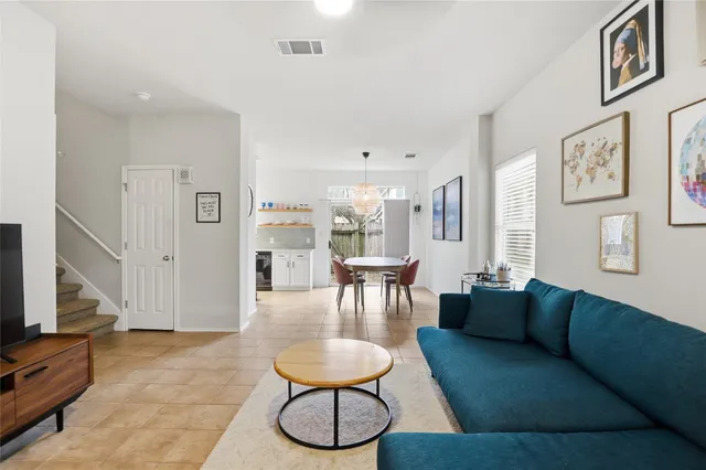 a living room with furniture potted plant and a flat screen tv