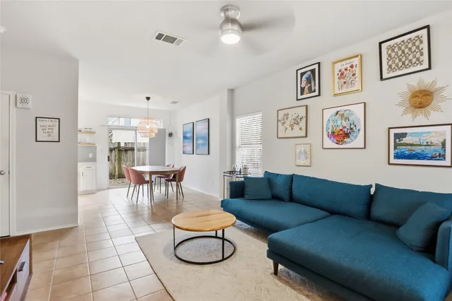 a living room with furniture a rug and kitchen view