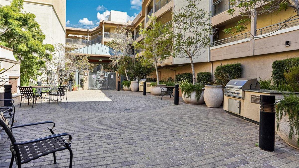 1388 Broadway, Unit 407 Millbrae, CA 94030 - Photo 27 of 28 a view of a patio with table and chairs with wooden fence and plants