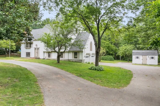 a view of a house with a big yard and large trees