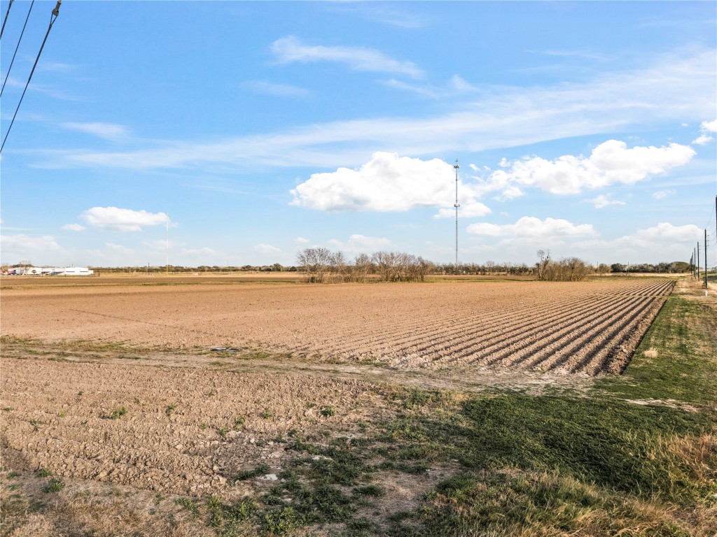 0 Hartledge Road Rosenberg, TX 77471 - Photo 8 of 13 Expansive, flat agricultural land with open skies, ideal for farming or development, offering a peaceful rural setting with distant views of structures and power lines.