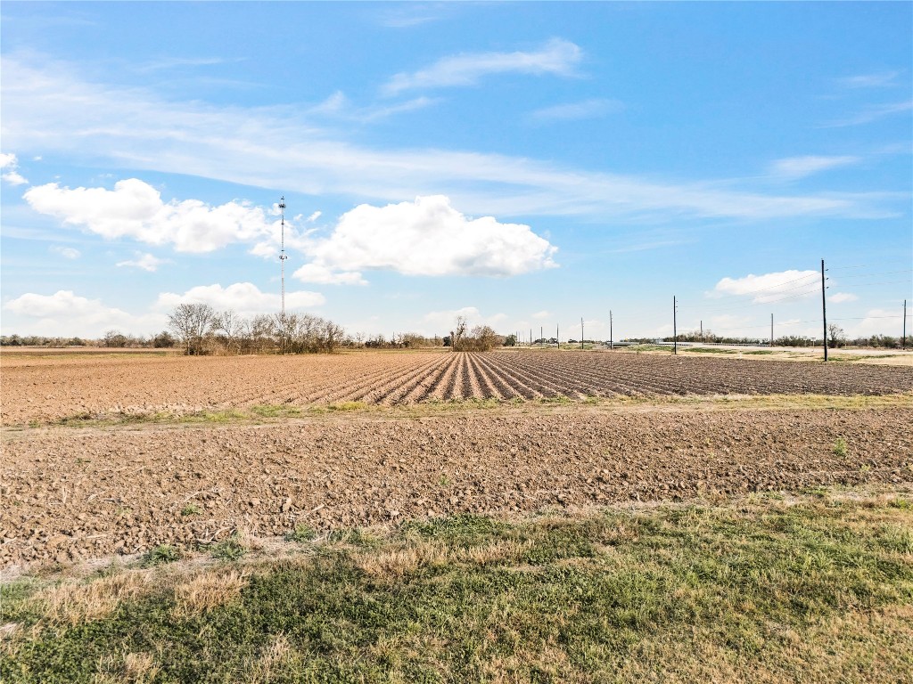 0 Hartledge Road Rosenberg, TX 77471 - Photo 9 of 13 Expansive agricultural land with neatly plowed fields under a bright blue sky, offering a rural setting with potential for farming or development.