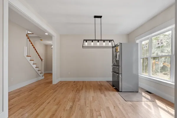 a view of empty room with wooden floor fan and window
