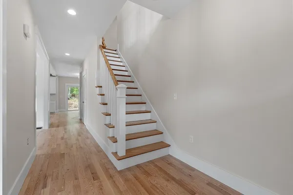 a view of a hallway with wooden floor and entryway