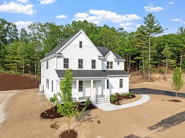 a front view of a house with a yard and potted plants