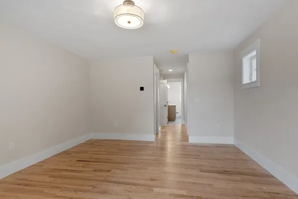 a view of a room with wooden floor and white walls