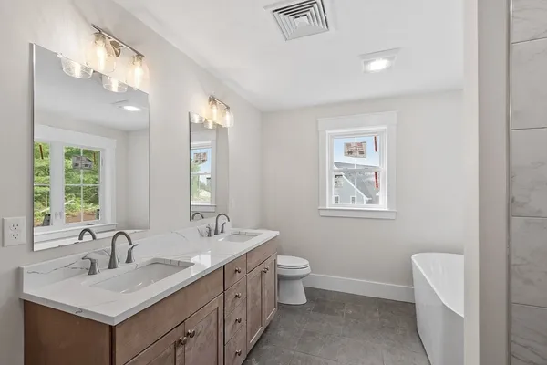 a bathroom with 2 sink and a bathtub