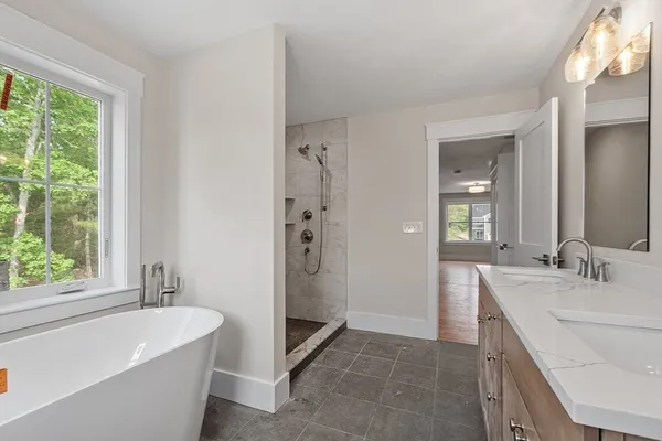 a bathroom with a bathtub a sink a vanity and a shower