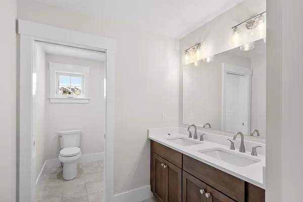 a bathroom with a toilet a sink a and mirror