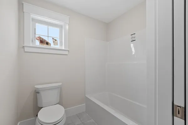 a white toilet sitting next to a bath tub