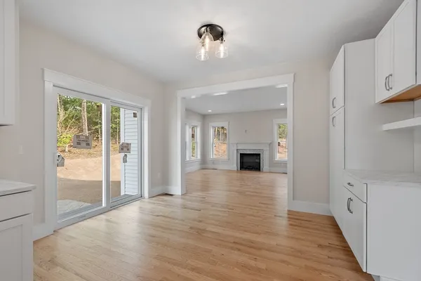 a view of a hallway with wooden floor and a fireplace