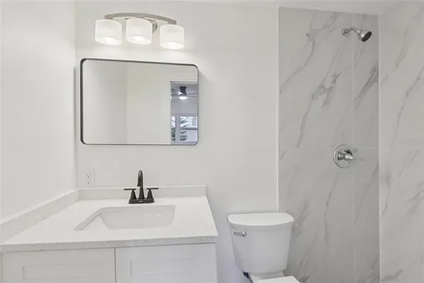 a bathroom with a sink a toilet and mirror