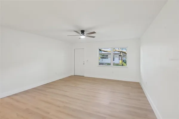 an empty room with fan and windows