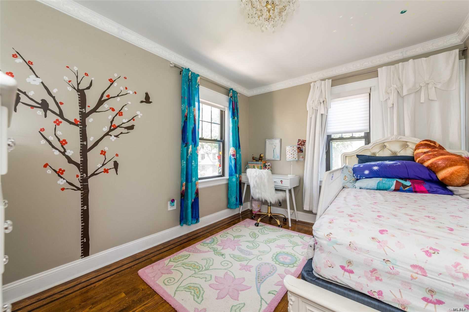 85-36 Wareham Place Queens, NY 11432 - Photo 11 of 26 a bedroom with a large bed window and a chandelier