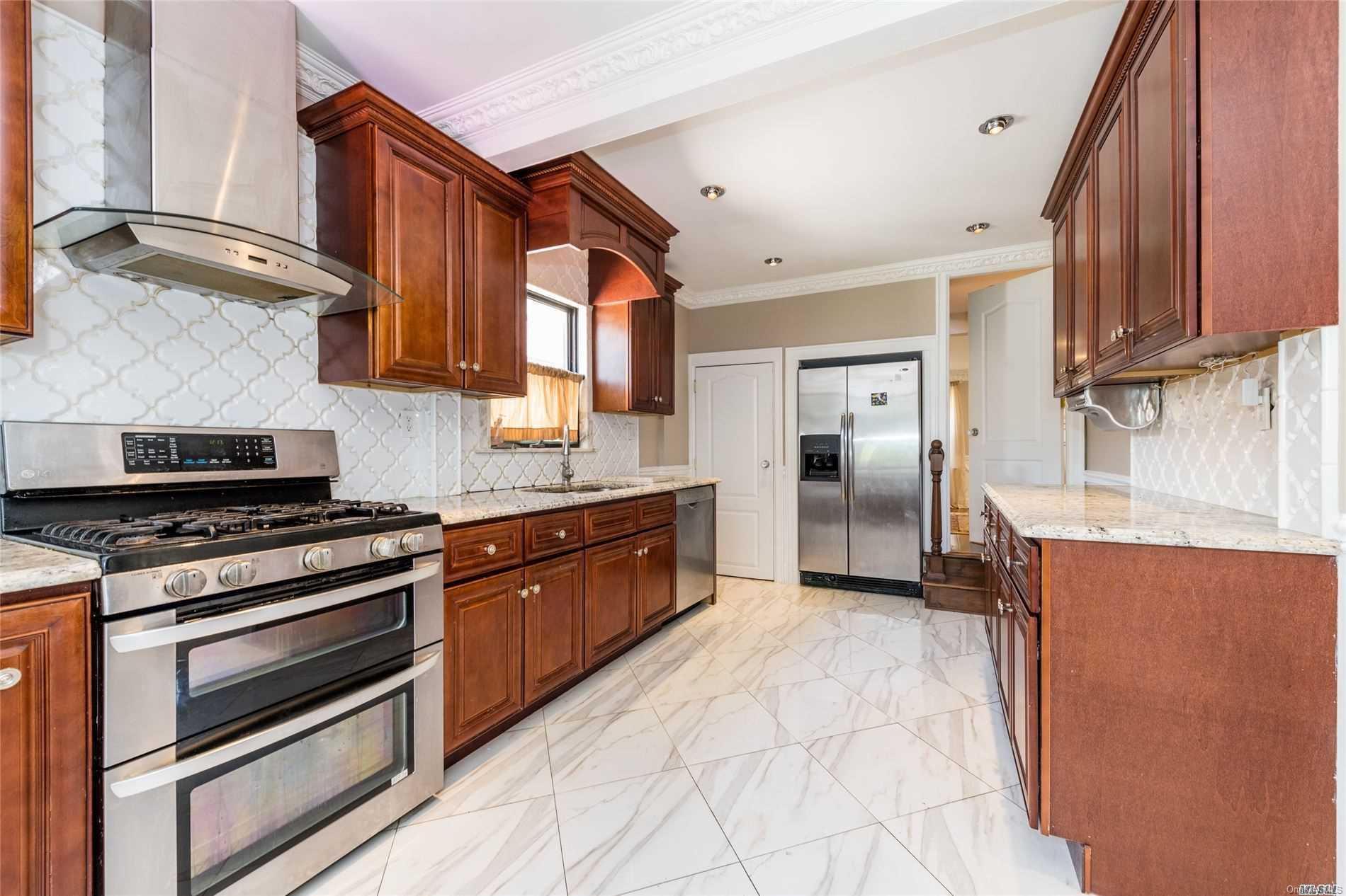85-36 Wareham Place Queens, NY 11432 - Photo 7 of 26 a kitchen with stainless steel appliances granite countertop a stove a sink and a refrigerator