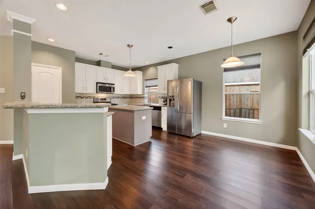 a kitchen with stainless steel appliances granite countertop a refrigerator a stove top oven a sink dishwasher and a refrigerator