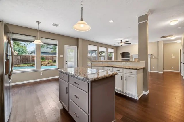a kitchen with granite countertop a stove and a wooden floors
