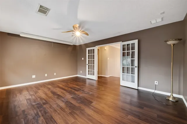 a view of an empty room with a window and wooden floor