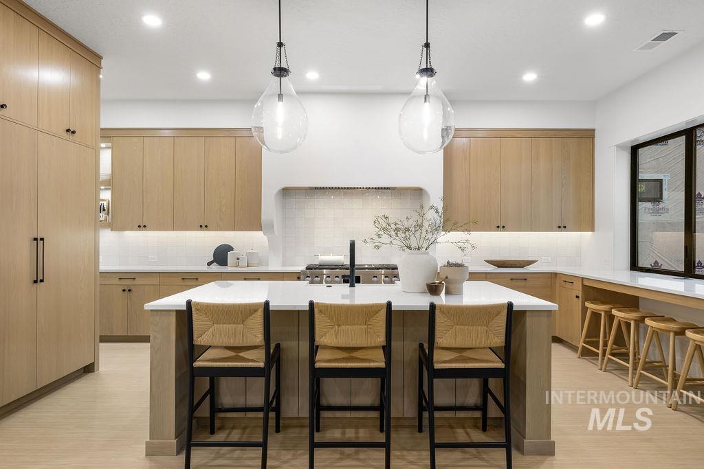 494 Century Avenue Middleton, ID 83644 - Photo 17 of 50 Kitchen with a kitchen breakfast bar, pendant lighting, light brown cabinetry, a kitchen island with sink, and recessed lighting
