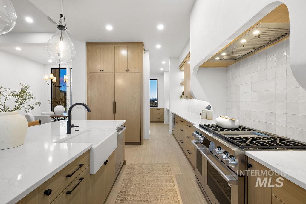 494 Century Avenue Middleton, ID 83644 - Photo 19 of 50 Kitchen with stainless steel appliances, modern cabinets, tasteful backsplash, light stone countertops, and pendant lighting