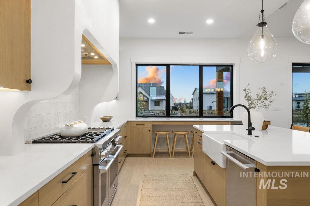 494 Century Avenue Middleton, ID 83644 - Photo 22 of 50 Kitchen featuring appliances with stainless steel finishes, light stone countertops, pendant lighting, modern cabinets, and light wood finished floors