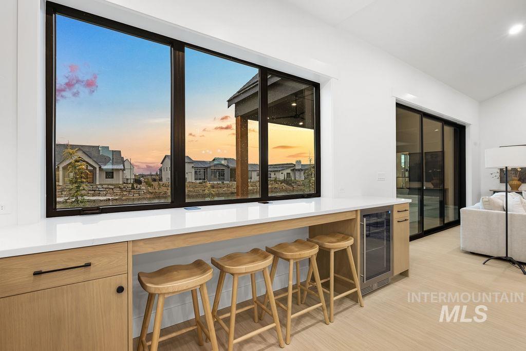 494 Century Avenue Middleton, ID 83644 - Photo 23 of 50 Kitchen featuring beverage cooler, a kitchen breakfast bar, light wood finished floors, light brown cabinets, and lofted ceiling