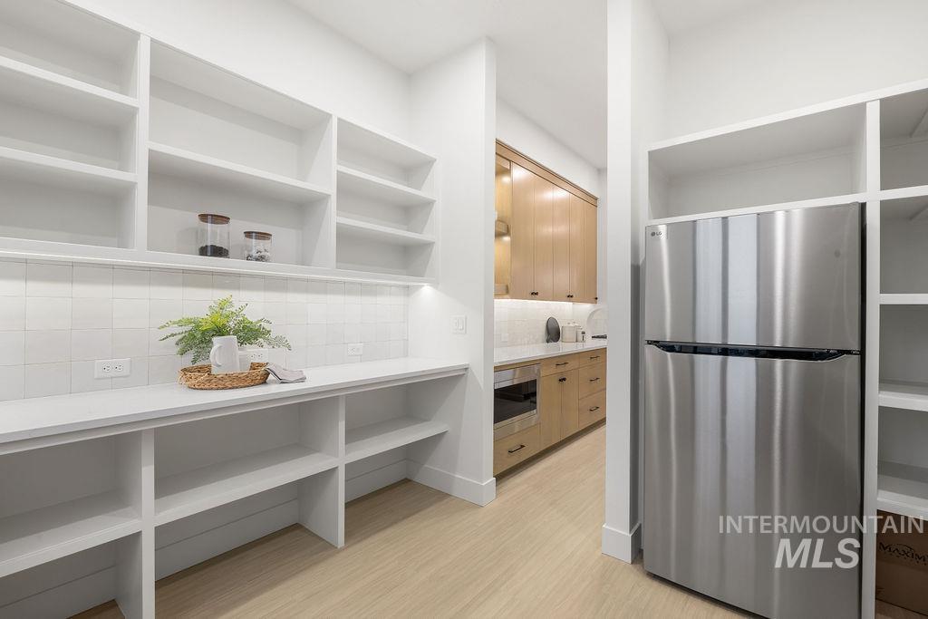494 Century Avenue Middleton, ID 83644 - Photo 26 of 50 Bathroom featuring a stall shower, light wood-type flooring, decorative backsplash, vanity, and a closet